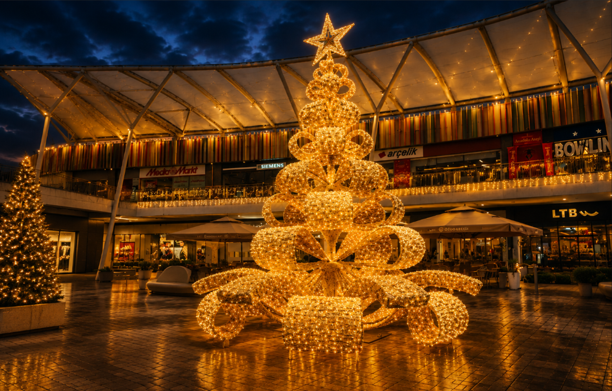 Large illuminated Christmas tree installation in a shopping mall plaza